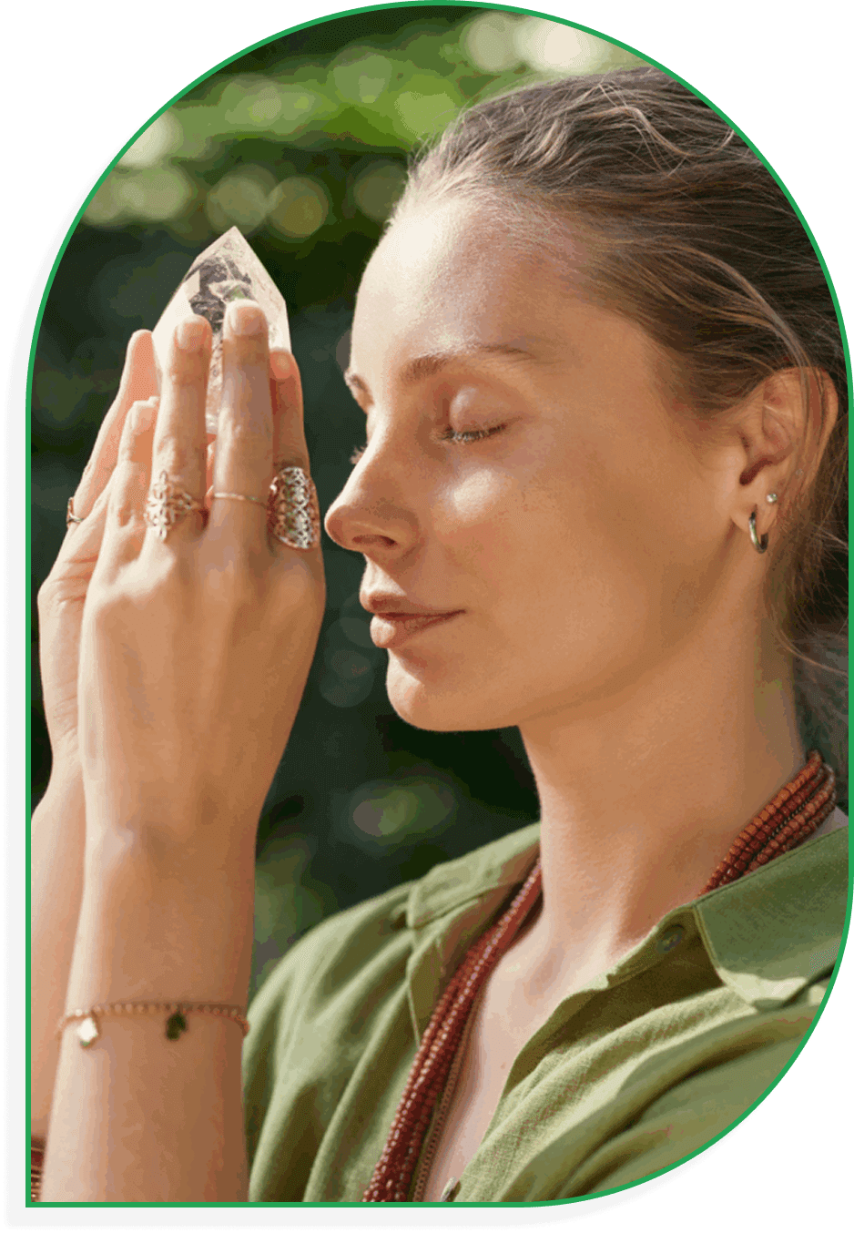 Woman with closed eyes praying outdoors with hands together.