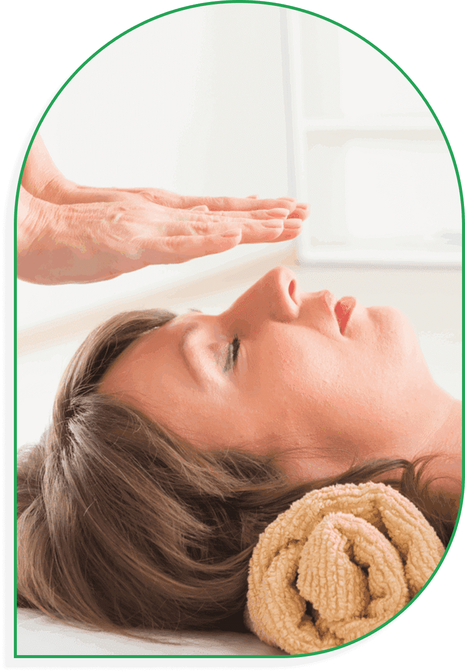 Person receiving a healing energy treatment with a hand hovering above the forehead.